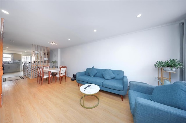 living area with recessed lighting, light wood-style flooring, and ornamental molding