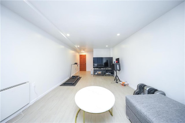 living area featuring radiator heating unit, recessed lighting, light wood-style flooring, and baseboards