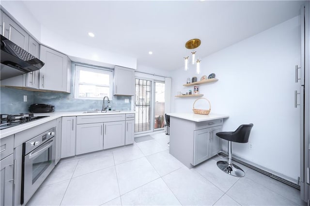 kitchen featuring stainless steel oven, gray cabinets, a sink, and recessed lighting