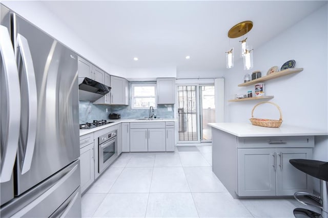 kitchen with appliances with stainless steel finishes, gray cabinets, under cabinet range hood, and recessed lighting