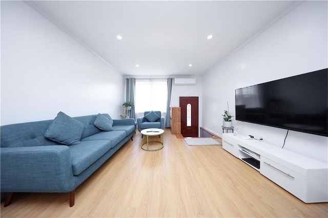 living room featuring a wall mounted air conditioner, light wood-style floors, and recessed lighting