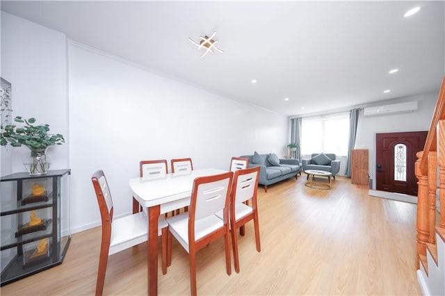 dining area featuring a wall mounted AC, light wood-style flooring, and recessed lighting