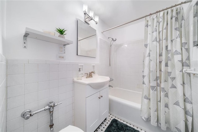bathroom featuring vanity, a wainscoted wall, shower / tub combo with curtain, and tile walls
