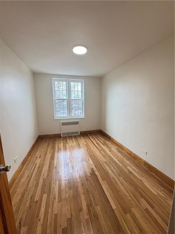 2239 Troy Ave Unit 3N, Brooklyn, NY 11234 - spare room with radiator heating unit, light wood-style flooring, and baseboards