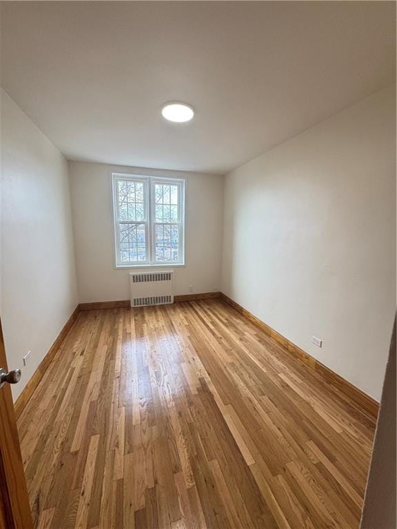 2239 Troy Ave Unit 3N, Brooklyn, NY 11234 - empty room featuring radiator heating unit, light wood finished floors, and baseboards