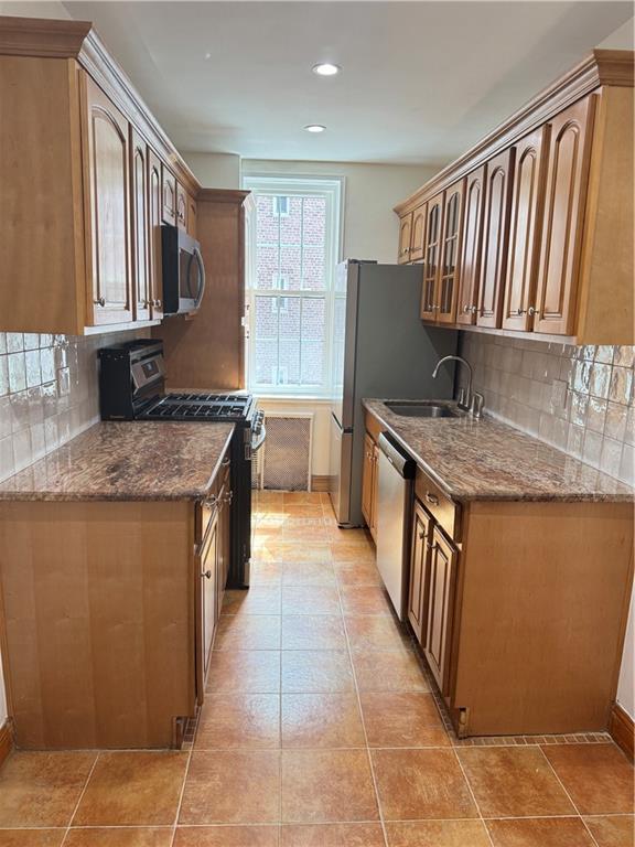 2239 Troy Ave Unit 3N, Brooklyn, NY 11234 - kitchen with stainless steel appliances, a sink, decorative backsplash, dark stone counters, and recessed lighting