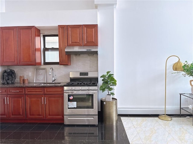31-47 137th St Unit 4B, Brooklyn, NY 11354 - kitchen featuring stainless steel gas range oven, dark brown cabinets, a baseboard heating unit, decorative backsplash, and under cabinet range hood
