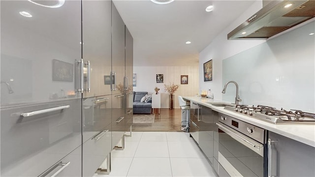 kitchen featuring custom exhaust hood, appliances with stainless steel finishes, modern cabinets, a sink, and recessed lighting