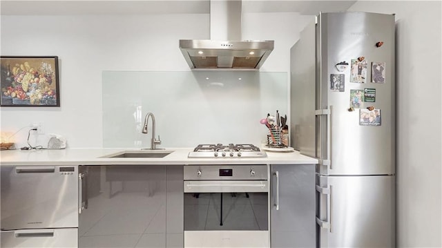kitchen featuring range hood, appliances with stainless steel finishes, a sink, light countertops, and gray cabinetry