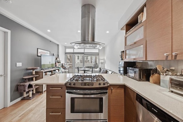 282 21st St Unit 2C, Brooklyn, NY 11215 - kitchen featuring stainless steel appliances, island range hood, light countertops, decorative backsplash, and a peninsula