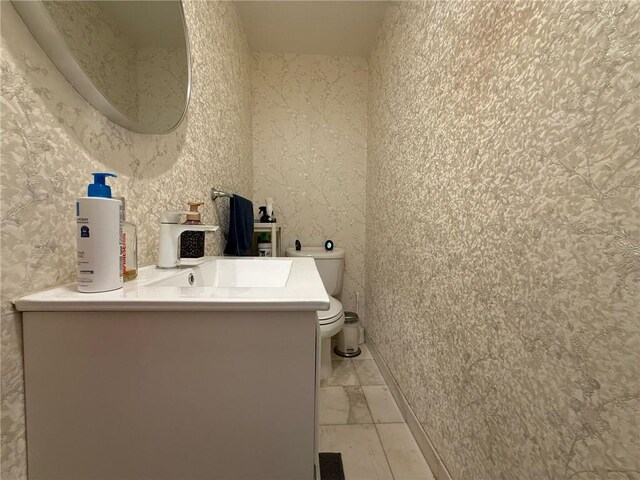 bathroom with vanity, marble finish floor, and toilet