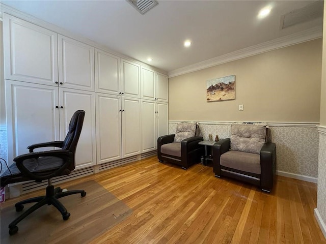 office area with light wood-style flooring, ornamental molding, visible vents, recessed lighting, and a wainscoted wall
