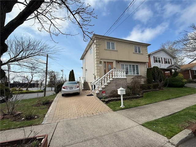 view of front of house featuring decorative driveway and stucco siding