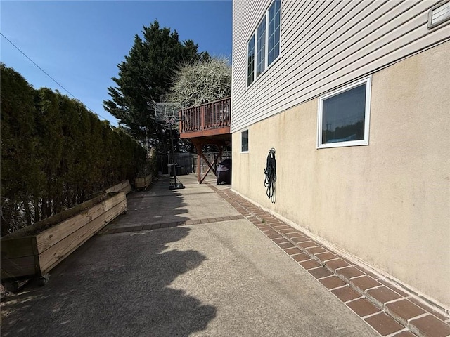 view of home's exterior featuring a patio area, a deck, and stucco siding