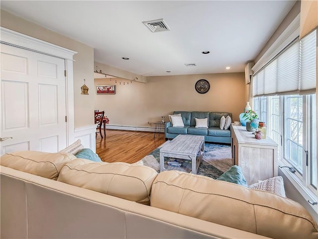 living room with a baseboard radiator, wood finished floors, visible vents, and recessed lighting