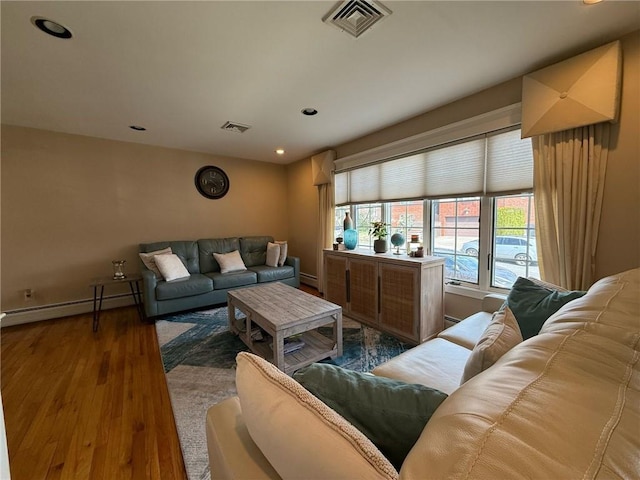 living room with baseboard heating, baseboards, recessed lighting, visible vents, and wood finished floors