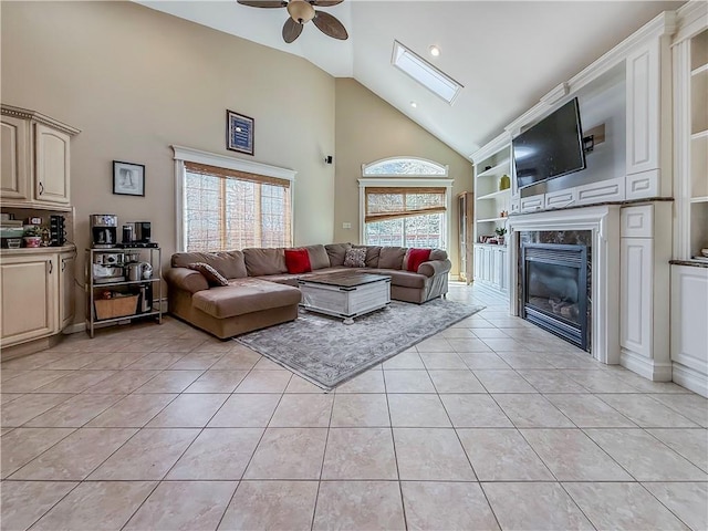 living area with high vaulted ceiling, light tile patterned floors, a fireplace, a ceiling fan, and built in shelves