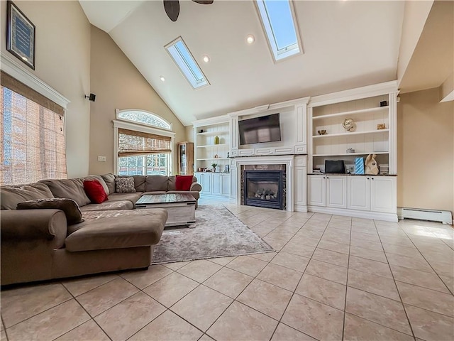 living area with light tile patterned floors, a fireplace, a skylight, high vaulted ceiling, and a baseboard heating unit