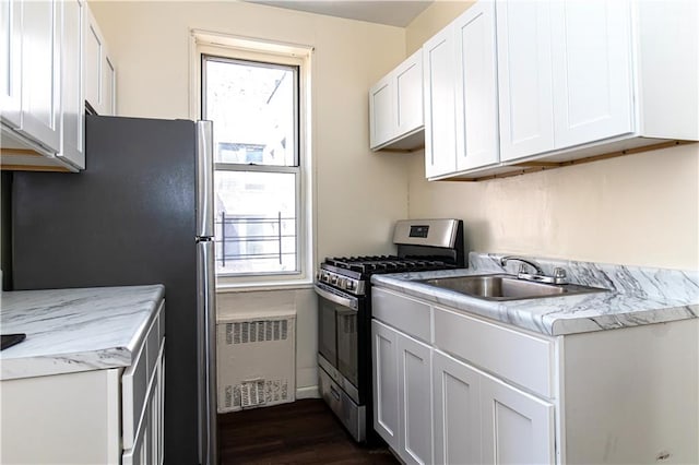 50 Kenilworth Pl Unit 5M, Brooklyn, NY 11210 - kitchen with appliances with stainless steel finishes, radiator, dark wood finished floors, light countertops, and healthy amount of natural light