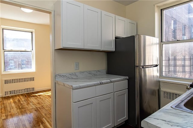 50 Kenilworth Pl Unit 5M, Brooklyn, NY 11210 - kitchen with radiator, freestanding refrigerator, wood-type flooring, and light countertops