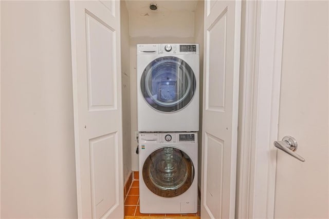 washroom with stacked washer / drying machine and tile patterned floors