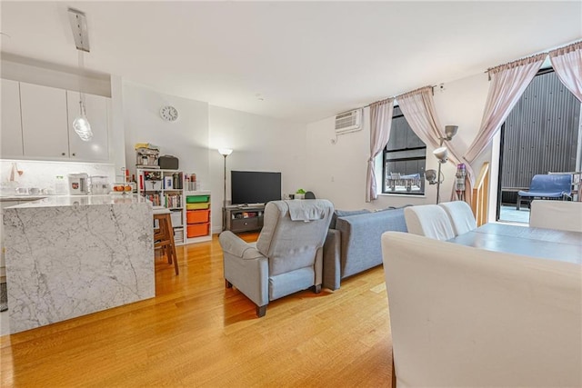 living area with light wood-style floors and a wall mounted AC