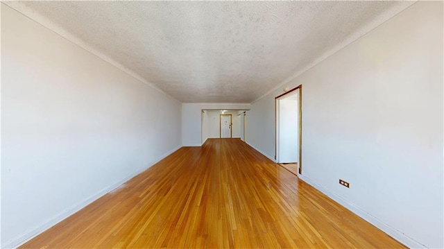 7401 Shore Rd Unit 6F, Brooklyn, NY 11209 - spare room with baseboards, light wood-type flooring, and a textured ceiling
