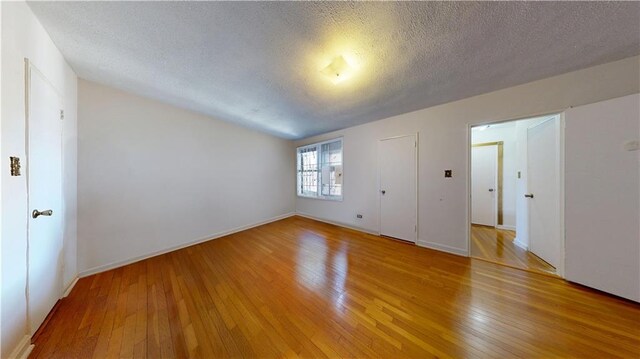 7401 Shore Rd Unit 6F, Brooklyn, NY 11209 - unfurnished bedroom with a textured ceiling, light wood finished floors, and baseboards