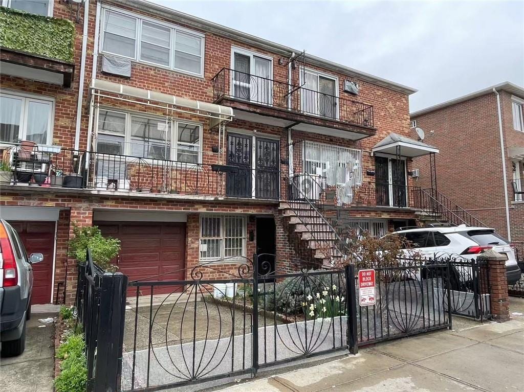 1931 85th St, Brooklyn, NY 11214 - view of property featuring brick siding, a fenced front yard, and a garage