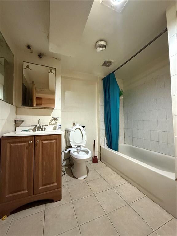 full bathroom featuring vanity, toilet, tile patterned flooring, and shower / bath combo with shower curtain