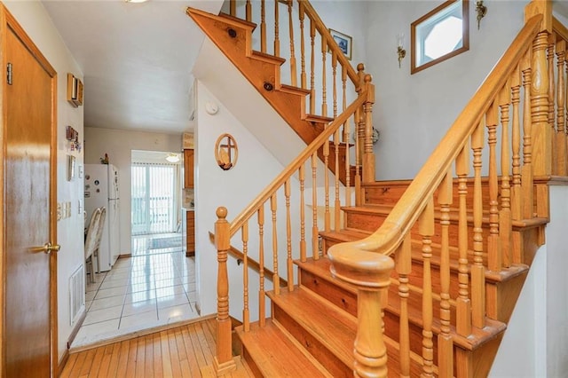 stairway featuring hardwood / wood-style flooring, visible vents, and a healthy amount of sunlight