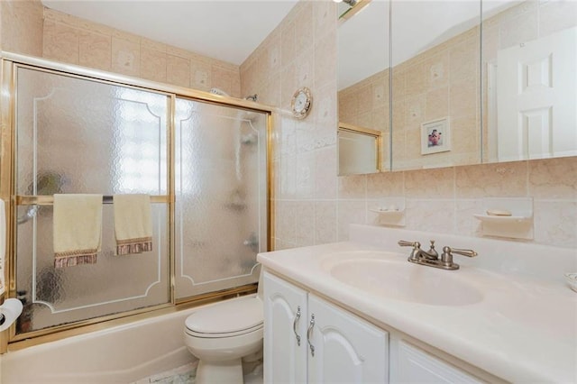 bathroom with decorative backsplash, vanity, tile walls, enclosed tub / shower combo, and toilet