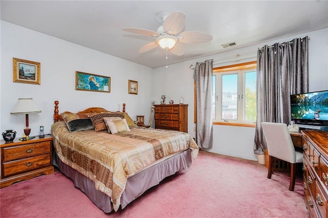 bedroom featuring a ceiling fan, visible vents, and light colored carpet