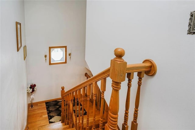 staircase featuring wood finished floors and baseboards