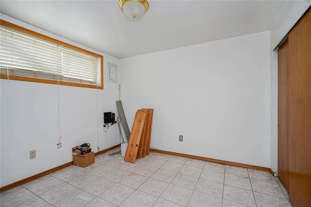 interior space featuring baseboards and light tile patterned flooring