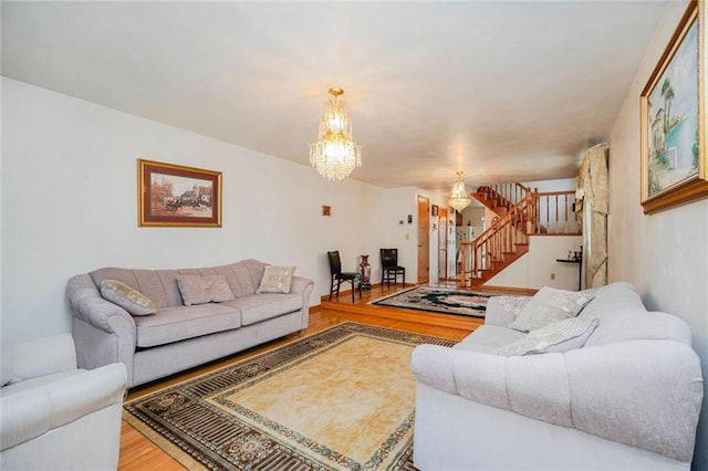 living area featuring an inviting chandelier, stairway, and wood finished floors