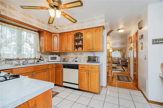 kitchen featuring light countertops, plenty of natural light, a sink, and white appliances