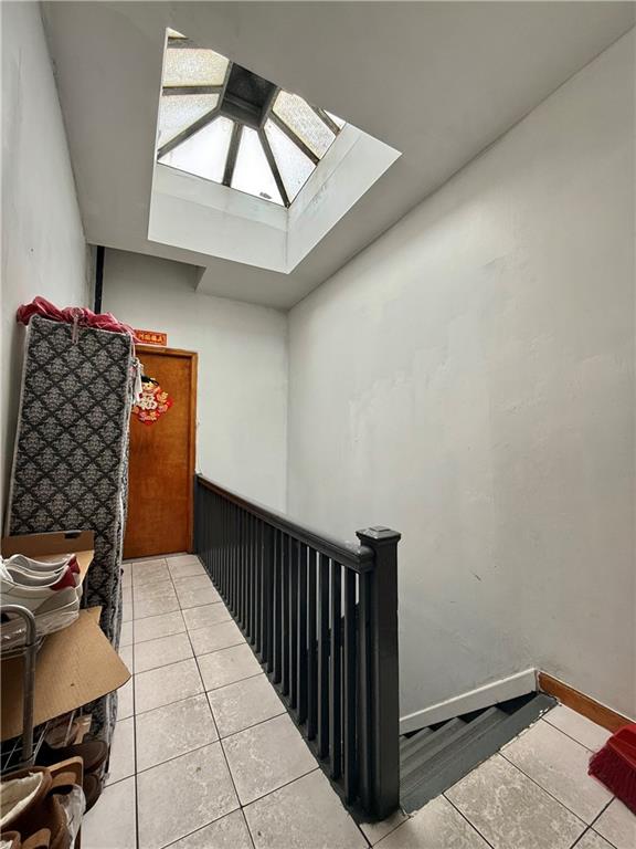 746 68th St, Brooklyn, NY 11220 - staircase with a skylight and tile patterned flooring