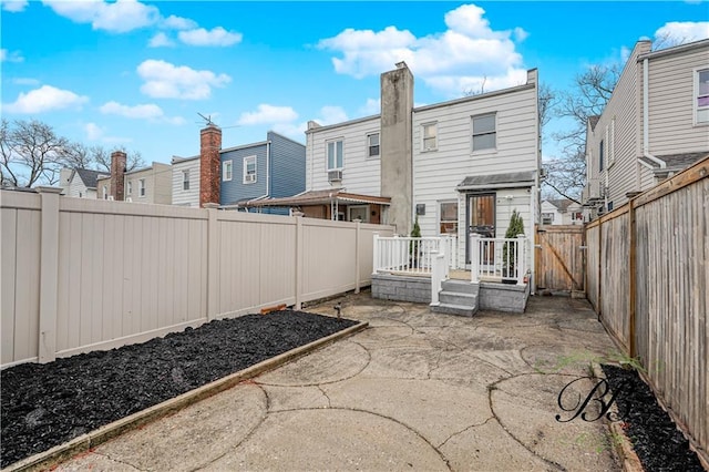 back of house featuring a fenced backyard, a patio area, and a residential view