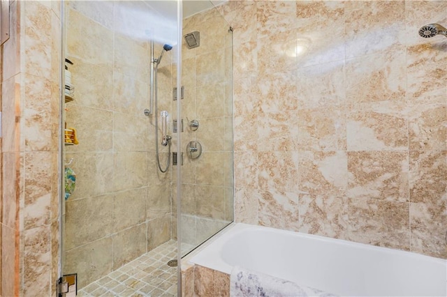 bathroom with a shower stall and a garden tub