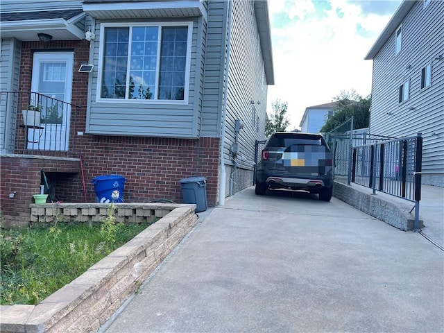 81 Burgundy Loop, Staten Island, NY 10304 - view of side of property featuring concrete driveway, brick siding, and fence