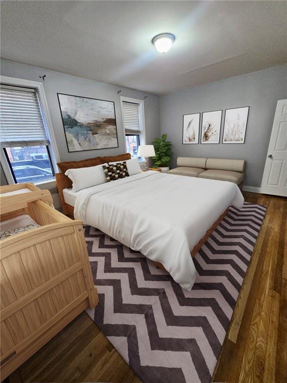 bedroom featuring baseboards and dark wood-style floors
