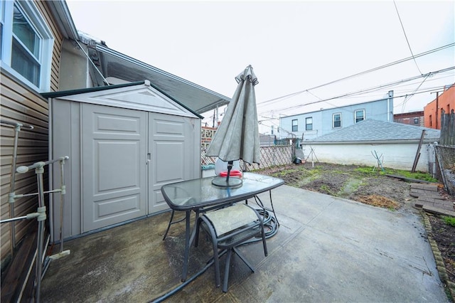 view of patio / terrace with fence, an outbuilding, and a storage shed