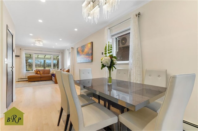 dining room featuring a chandelier, recessed lighting, baseboard heating, and light wood finished floors