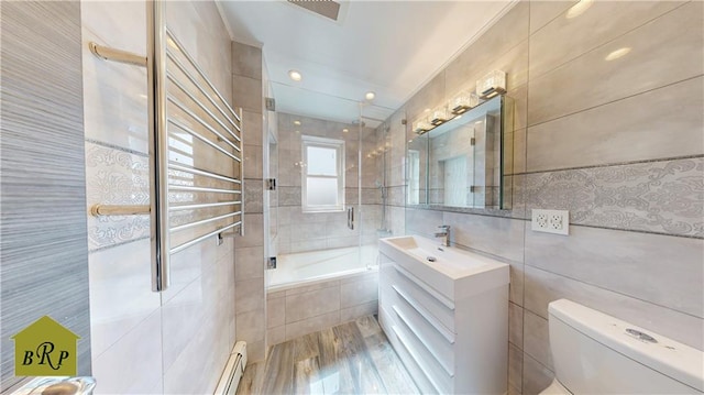 full bathroom featuring tile walls, vanity, toilet, visible vents, and tiled shower / bath combo