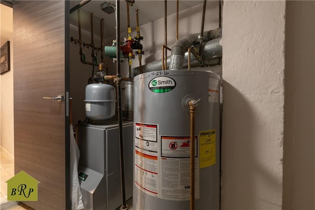 utility room featuring gas water heater and washer / dryer