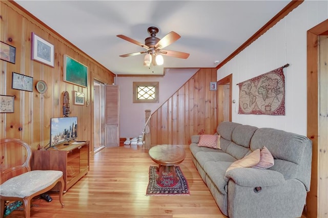 447 Greeley Ave, Staten Island, NY 10306 - living room with ornamental molding, light wood-type flooring, ceiling fan, stairway, and wood walls