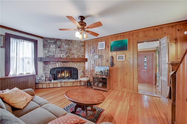 447 Greeley Ave, Staten Island, NY 10306 - living area featuring ceiling fan, light wood-style floors, a stone fireplace, wood walls, and crown molding