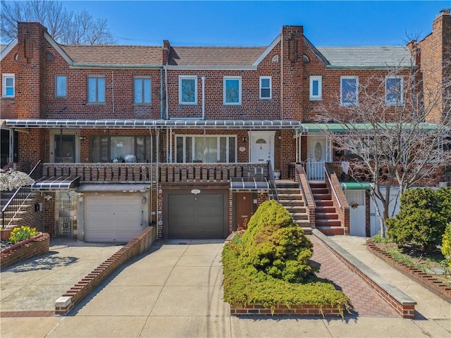 4640 Bedford Ave, Brooklyn, NY 11235 - view of front facade featuring a garage, brick siding, driveway, and stairway