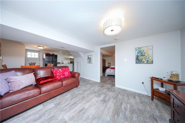 living area with baseboards and wood finished floors